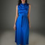 Žena nosi plavu satensku haljinu midi dužine bez rukava.