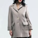 The girl is wearing a beige woolen coat.