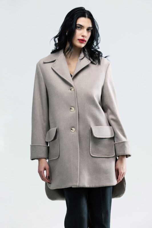 The girl is wearing a beige woolen coat.