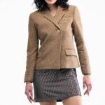 Žena nosi kratki, strukirani blejzer u kamel boji.