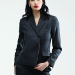 The girl wears a tight, grey, waisted blazer.