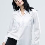 The girl is wearing a white cotton shirt.