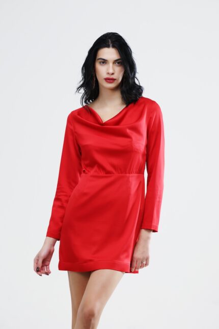 The girl wears a short red satin dress with long sleeves.