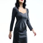 Devojka nosi sivu haljinu midi dužine sa dugim rukavima.