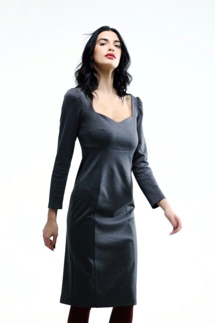 The girl wears a grey midi-length dress with long sleeves.