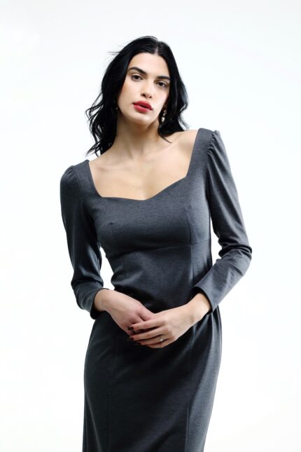 The girl wears a grey midi-length dress with long sleeves.