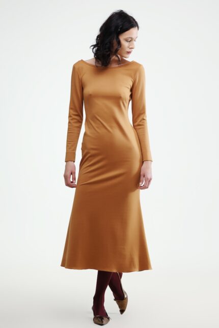 The woman wears a brown midi-length dress with long sleeves.