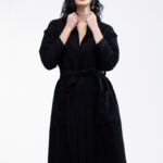 Devojka nosi NOA kaput na vezivanje od crnog buklea.