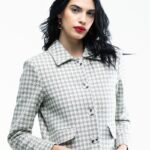 Devojka nosi sivo-beli karirani kratki SIMONE blejzer.