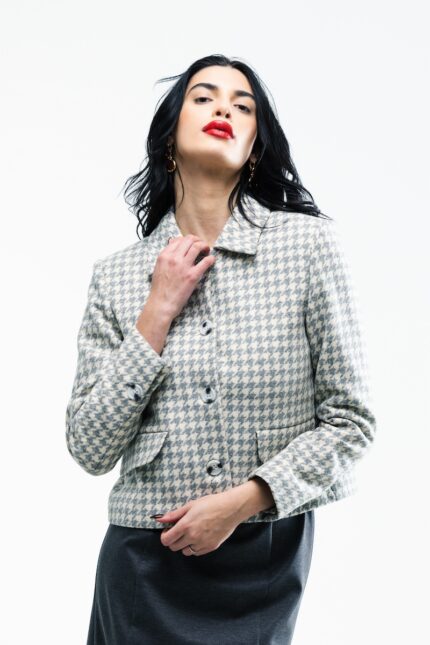 The girl wears a gray and white houndstooth short SIMONE blazer.