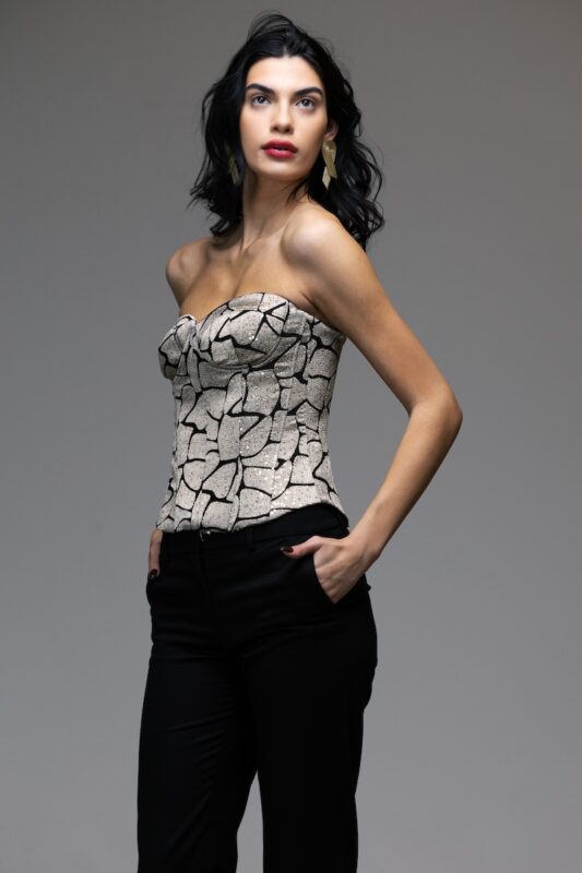 The girl wears a patterned VANJA corset with gold rhinestones.