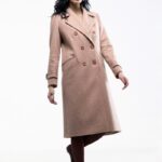 The girl wears an apricot double-breasted midi coat.