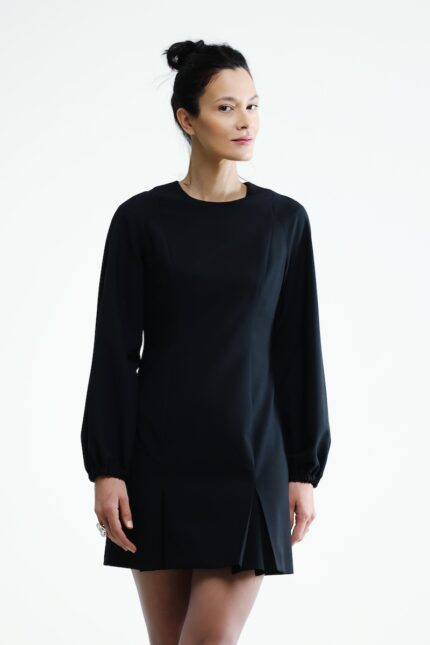 The woman wears a short black dress with black sleeves.