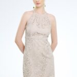 Model nosi kratku bež haljinu od čipke.