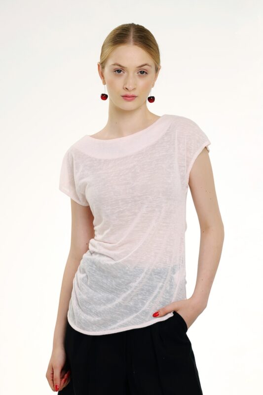 Model nosi bledo roze bluzu kratkih rukava.