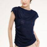 Model nosi pamučnu teget majicu kratkih rukava sa orkuglim izrezom.