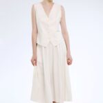 Model nosi strukirani prsluk krem bele boje.