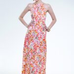 Model nosi dugu cvetnu haljinu bez rukava.