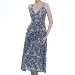 Devojka nosi šarenu midi haljinu na bretele, sa v izrezom.