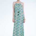 Model nosi dugu haljinu u tirkiznom, cvetnom dezenu.