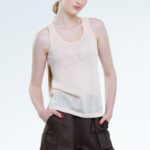 Model nosi bluzu sa širokim bretelama u boji kajsije.