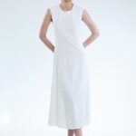 Model nosi midi haljinu bez rukava bele boje.