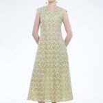 Model nosi midi haljinu od žute čipke.