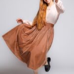 Devojka nosi midi žuto-crvenu suknju sa tilom.