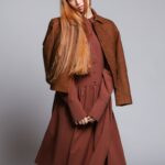 The model is wearing a brown midi dress with long sleeves.