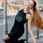 The model is wearing a black halter top paired with black shorts.