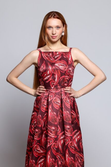 The girl is wearing a red patterned midi dress.