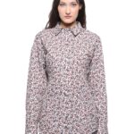 Devojka nosi košulju cvetnog dezena u kombinaciji sa sivim pantalonama.