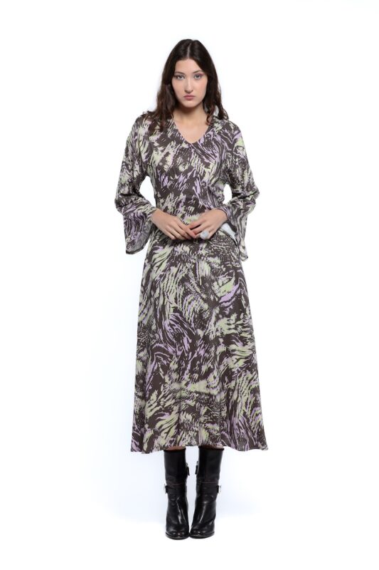 Devojka nosi dezeniranu midi haljinu sa dugim rukavima