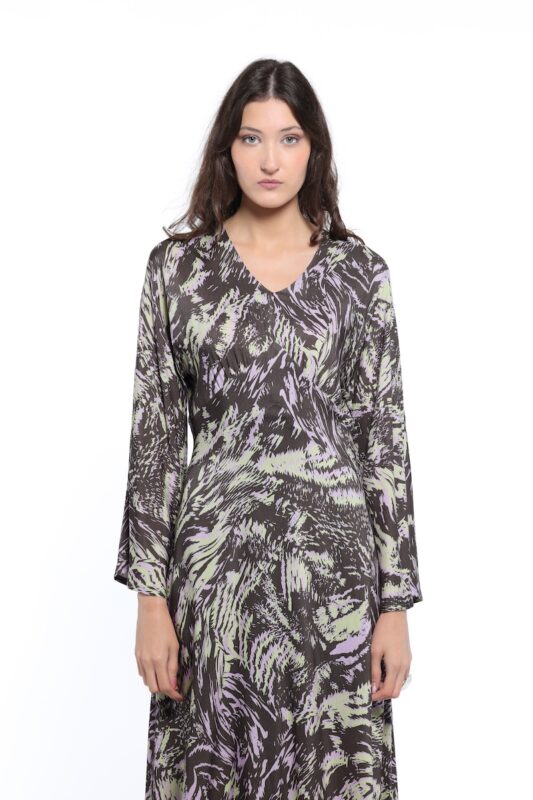 Devojka nosi dezeniranu midi haljinu sa dugim rukavima