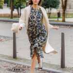 The model is wearing a midi patterned dress with 3/4 sleeves.