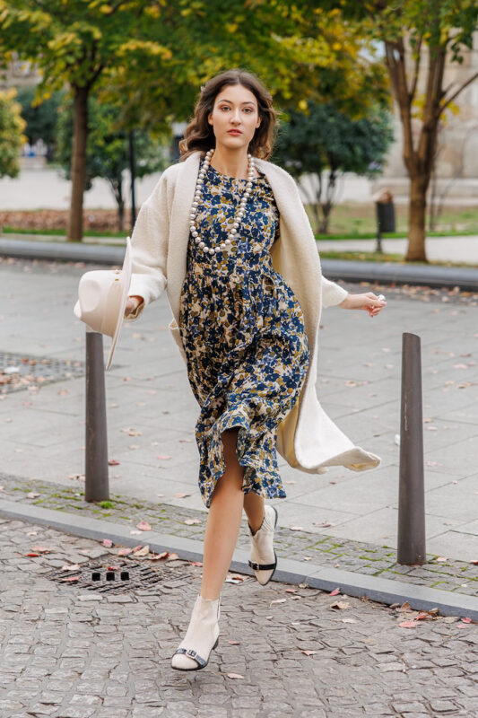The model is wearing a midi patterned dress with 3/4 sleeves.