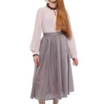 The model is wearing a midi gray skirt paired with a blush pink blouse.